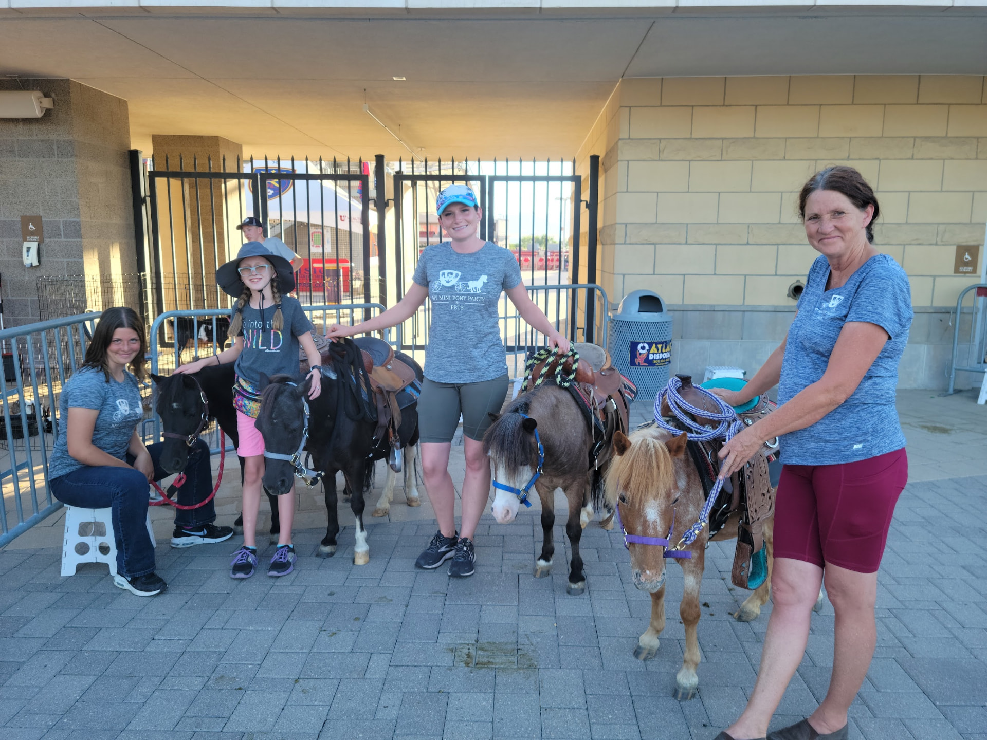 Our team with saddled mini ponies ready for pony rides at a stadium event